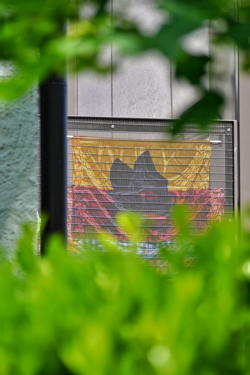 An outdoor HVAC unit stands against a paneled wall.